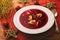 Traditional Polish christmas soup - red borscht soup with dumplings on white plate.