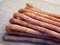 Traditional Polish sausages Kabanos on a wooden surface, macro photo. Kabanos, also known as cabanossi or kabana, is a long, thin