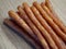 Traditional Polish sausages Kabanos on a wooden surface, macro photo. Kabanos, also known as cabanossi or kabana, is a long, thin