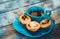 Traditional Portuguese cakes pastel or pasteis de nata on the clay plate with a cup of coffee closeup on wooden background