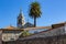 Traditional portuguese church with azulejos tiles with palm tree and old buildings. Mediterranean religious landmark.