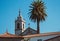 Traditional portuguese church with azulejos tiles with palm tree and old buildings. Mediterranean religious landmark.