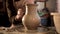 Traditional pottery making, close up of potter`s hands shaping a bowl on the spinning by clay