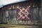 traditional quilt hanging on a weathered barn wall
