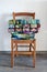 Traditional quilts stacked on wooden chair against neutral wall