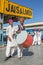 Traditional rajasthani musicians posing for photo under the big Jaisalmer sign on railway station.