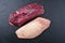 Traditional raw gourmet duck breast filet with skin on a black board