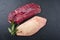 Traditional raw gourmet duck breast filet with skin with herbs on a black board