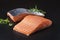 Traditional raw salmon fillet steaks with herbs on a black board