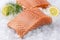 Traditional raw salmon fillet steaks with herbs and lemon slices on crashed ice