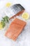 Traditional raw salmon fillet steaks with herbs and lemon slices on crashed ice