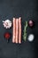 Traditional raw sausages, flat lay, on black background
