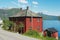 Traditional red painted Norwegian house with Sognefjord at the background in Balestrand, Norway.
