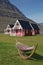 Traditional red painted wooden panel house with mighty Holmatindur mountain in the background in Eskifjordur, East Iceland