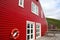 Traditional red painted wooden panel house with wooden slatted decking, Eskifjordur, East Iceland