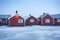 Traditional red wooden houses on the shore of Reine fjord. Beautiful winter scene of Vestvagoy island. Picturesque morning view