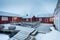 Traditional red wooden houses on the shore of Reine fjord. Beautiful winter scene of Vestvagoy island. Picturesque morning view