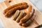 Traditional regional German green cabbage sausage variation of Oldenburger, Bremer and AmmerlÃ¤nder Pinkel on wooden cutting board