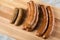 Traditional regional German green cabbage sausage variation of Oldenburger, Bremer and AmmerlÃ¤nder Pinkel on wooden cutting board