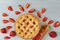 Traditional rhubarb strawberry pie on the gray kitchen table. Vegetarian pie decorated with fresh organic ingredients