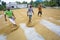 Traditional Rice Mill Worker turn over paddy for drying