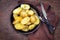 Traditional roast potatoes with herbs in an iron cast pan