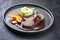 Traditional roasted beef heart with fried pumpkin slices and mashed potatoes in gravy red wine sauce on a modern design