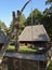 Traditional Romanian household with wooden house and fountain in the yard