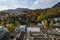 Traditional rooftops of a Hanok village. Forest and hills at the background. Autumn leaves, red and green colors. Bukchon hanok