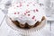 Traditional Russian Easter bread kulich pie with sugar fondant and heart\\\'s on a white shabby chic cake plate