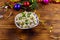 Traditional Russian festive salad Olivier and New Years decorations on wooden table