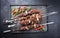 Traditional Russian lamb shashlik on a barbecue skewer with chili, onion and sumach on a rustic metal tray