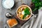 Traditional Russian soup-Rassolnik with pickled cucumber, barley, chicken, tomatoes and parsley in ceramic bowl. Selective focus.