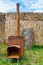 Traditional rusty metal wood oven in backyard in a sunny summer day.