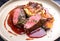 Traditional saddle of venison with Swiss roesti, quince and orange slices in game red wine sauce