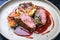 Traditional saddle of venison with Swiss roesti, quince and orange slices in game red wine sauce