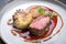 Traditional saddle of venison with Swiss roesti, quince and orange slices in game red wine sauce