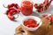 Traditional sauce adjika with hot chili pepper, paste harissa in bowl on wooden board. Closeup