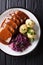 Traditional Sauerbraten dish with potato dumplings and red cabbage close-up. German cuisine. Vertical top view