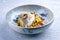 Traditional sauteed skrei cod fish filet with skin in a bed of Persian jeweled saffron rice pilaw