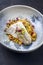 Traditional sauteed skrei cod fish filet with skin in a bed of Persian jeweled saffron rice pilaw  in a design bowl