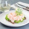 Traditional savory swedish sandwich with a dark bread, lettuce, eggs, mayonnaise, shrimps, dill and lemon, square format