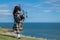 Traditional scottish bagpiper in full dress code at the ocean