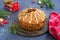 A traditional Scottish Christmas fruit Dundee cake with a mix of dried fruits, decorated with peeled almonds on a wooden board on