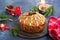 A traditional Scottish Christmas fruit Dundee cake with a mix of dried fruits, decorated with peeled almonds on a wooden board on