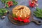 A traditional Scottish Christmas fruit Dundee cake with a mix of dried fruits, decorated with peeled almonds on a wooden board on