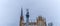 A traditional sculpture of Archangel Michael striking the devil with a spear against the sky and the church spire