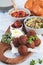 Traditional Shabbat table: challah bread, falafel, quinoa salad, hummus on a wooden board.