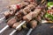 Traditional shashlik skewer with salad and yufka bread on an old burnt rustic cutting board