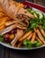 Traditional Shawarma Delight: Savory Chicken, Fries, and Fresh Veggies Wrapped in Pita - Rustic Brown Wall Setting. AI Generated